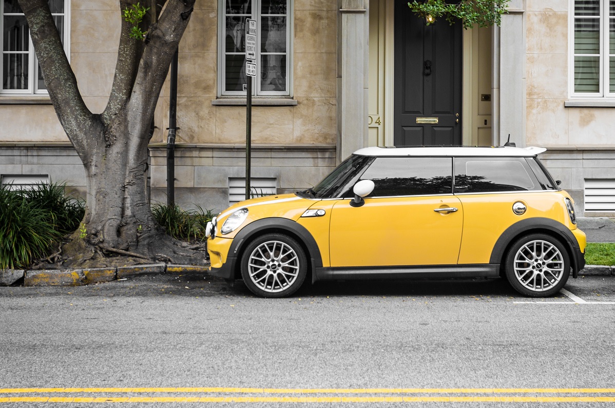 yellow mini cooper parked beside white concrete building 457418